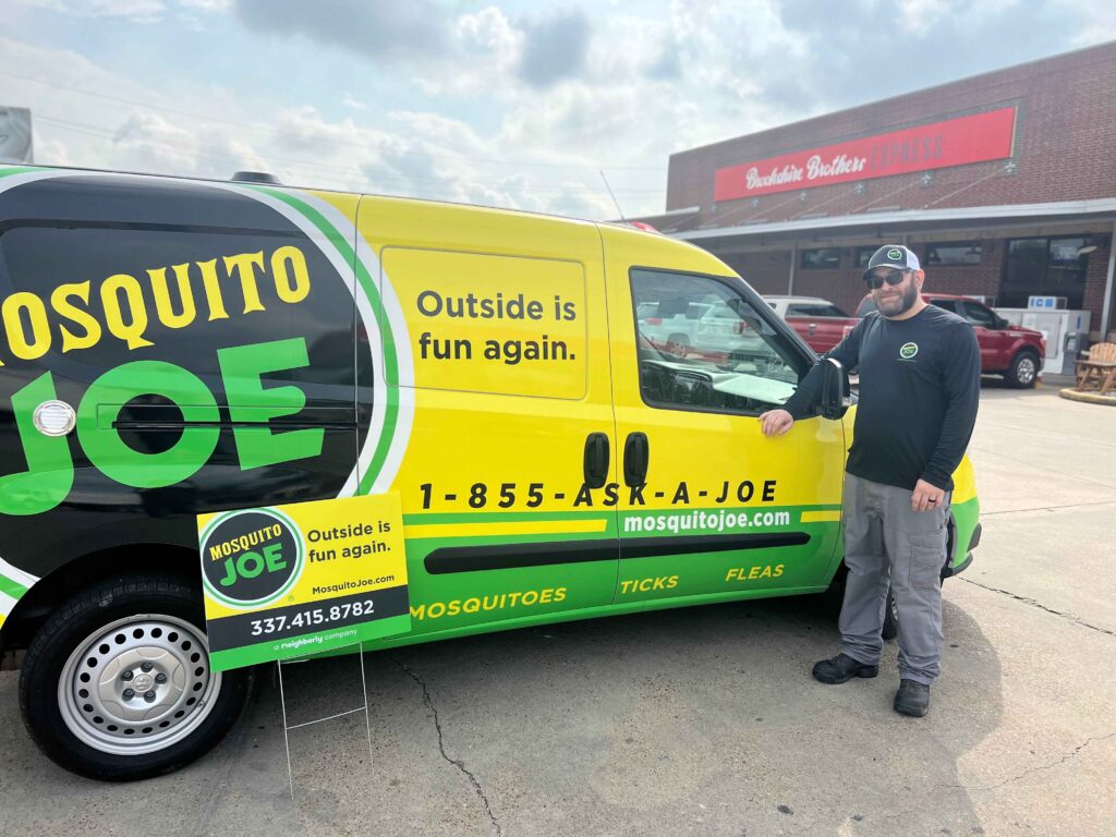 Mosquito Joe of Lake Charles technician with Mosquito Joe sign and van in front of Brookshire Brothers Express in Louisiana.